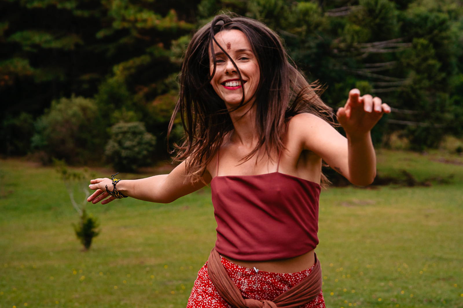 Fran Fischborn dançando e sorrindo em meio à natureza